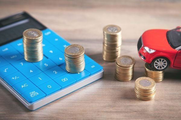 Car, coins, calculator on the desk.